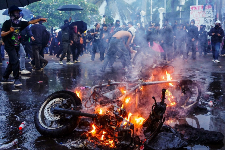 Protesters set fire to a police motorcycle during a demonstration against a revision to the armed forces law in front of the House of Representatives building in Jakarta on March 27, 2025. The Indonesian parliament approved the amendment of the military law on March 20, despite protests that it would expand the armed forces' role in civilian affairs. The revision to the armed forces law, pushed mainly by President Prabowo Subianto's coalition, was aimed at expanding the military's role beyond defense in a country long influenced by its powerful armed forces. 