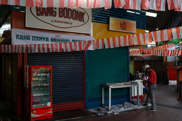Priced out: A newspaper vendor sells in front of a closed stall at District Blok M, South Jakarta, on Sept. 3, 2025. Several renters have left the location due to rent increases reaching Rp 15 million (US$907) per month.