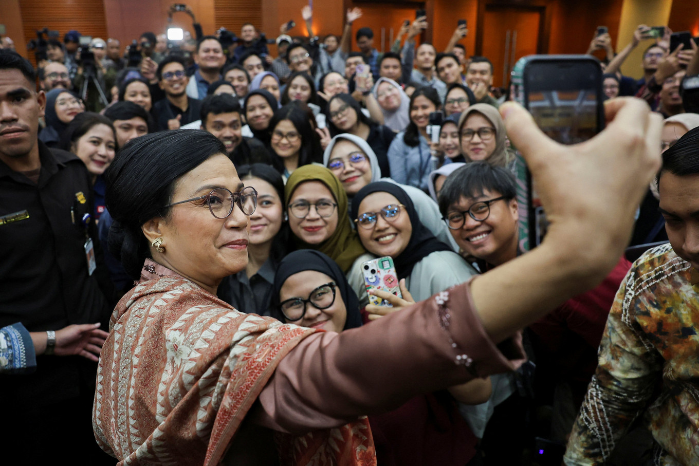 Former finance minister Sri Mulyani Indrawati takes a selfie with journalists following a handover ceremony at the Finance Ministry in Jakarta on Sept. 9, 2025.