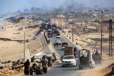 Vehicles move on Sept. 9 along the coastal road used by displaced people evacuating southbound from Gaza City in Nuseirat in the central Gaza Strip. Israel has been intensifying its bombardment of Gaza City in preparation for its military operation despite repeated entreaties from Western nations and aid agencies to stop.