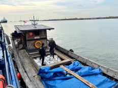 Two officers from the Batam Customs and Excise Office inspect a ship carrying 20 tonnes of illegal tin ore in this undated picture at the Customs Pier in Tanjung Uncang, Batam, Riau Islands. Customs intercepted the ship on Aug. 28, 2025.  