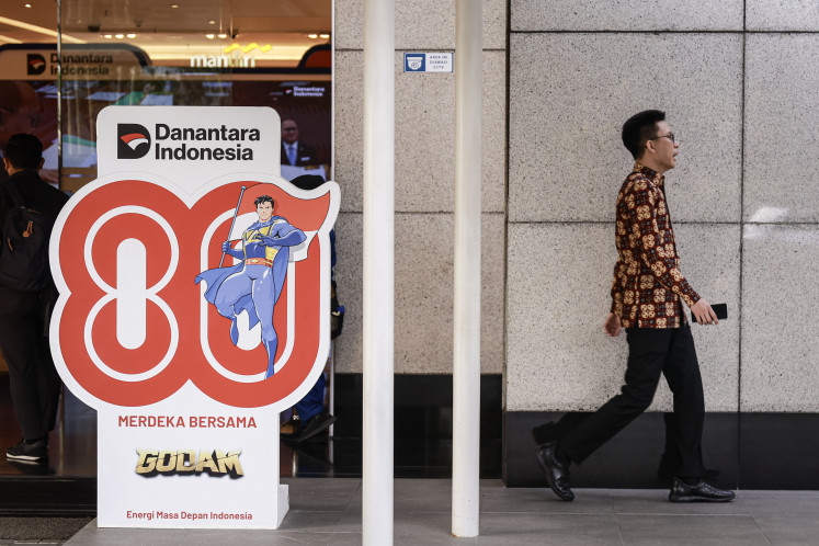 An employee walks past Indonesian Independence Day decorations at Wisma Danantara Indonesia, South Jakarta, on Sept. 8, 2025. In its first six months of operation, Danantara recorded several important achievements, including securing US$10 billion in funding from a consortium of 12 foreign banks.