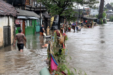 Residents wade through floodwaters in their neighborhood following heavy rainfall in Denpasar, Bali, on Sept. 10, 2025. 