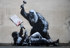 An artwork by street artist Banksy, depicting a judge using a gavel to beat a protester using a placard as protection, is pictured on a exterior wall of the The Royal Courts of Justice, Britain's High Court, in London on September 9, 2025. 