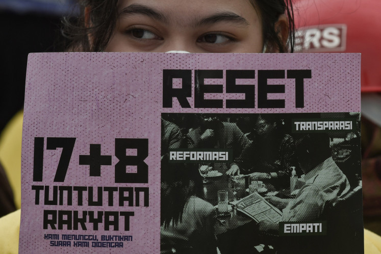 A female student holds a poster listing demands during a protest on Sept. 9 in front of the Senayan Legislative Complex in Central Jakarta. The action was carried out to advocate for the 17+8 People’s Demands reform framework.