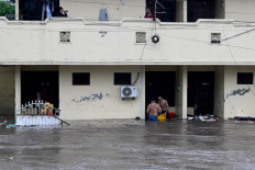 Residents wade through floodwaters in their neighbourhood following heavy rainfall on Sept. 10 in Denpasar, Bali.
