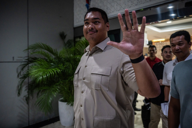 Former youth and sports minister Dito Ariotedjo (left) walks alongside Deputy Minister Taufik Hidayat (right) on Sept. 8 leaving the ministry's office in Jakarta. President Prabowo Subianto dismissed Dito from his ministerial post during a cabinet reshuffle on Sept. 8.