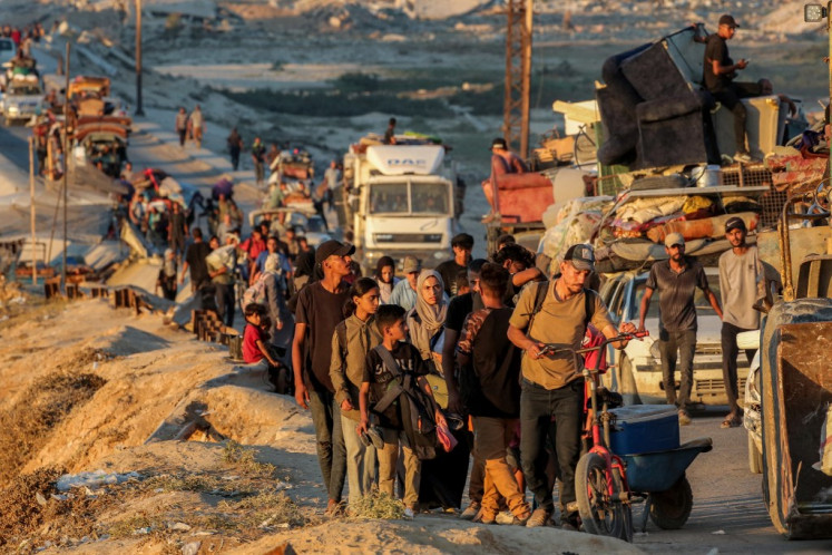 Displaced Palestinians evacuating southbound from Gaza City travel on foot and by vehicle along the coastal road in Nuseirat in the central Gaza Strip on September 13, 2025.  (Photo by / AFP)