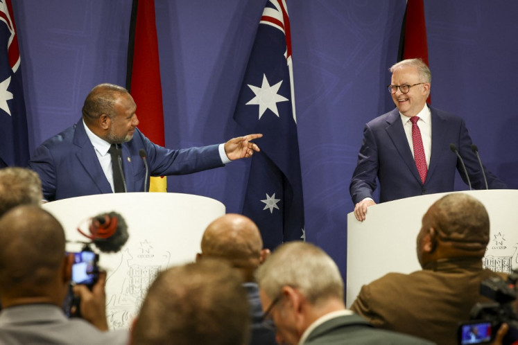 Australian Prime Minister Anthony Albanese (right) reacts as Papua New Guinea's Prime Minister James Marape speaks during a press conference in Sydney on Dec. 12, 2024.