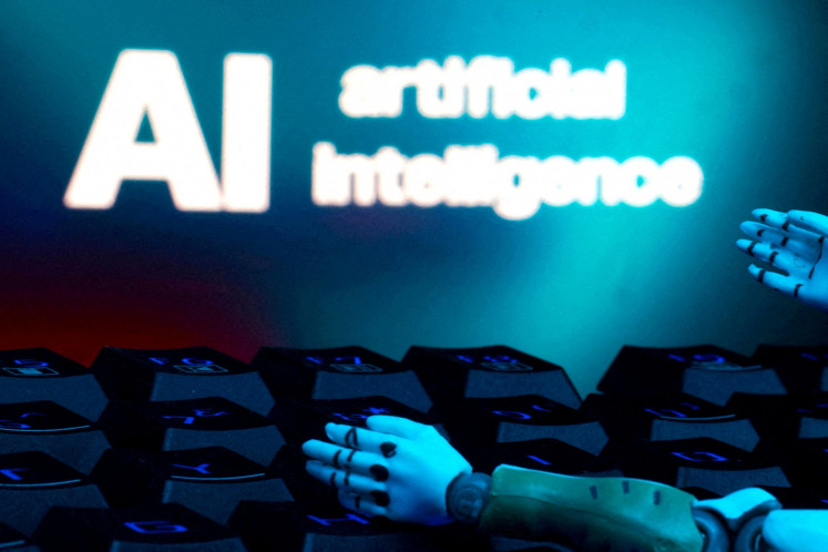 A message reading “AI artificial intelligence“, a keyboard and robot hands are seen in this illustration taken on Jan. 27.