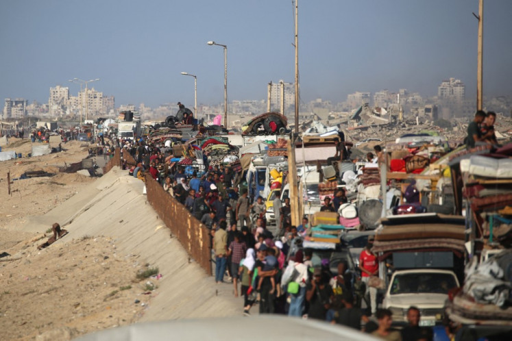 Displaced Palestinians move with their belongings southwards on a road in the Nuseirat refugee camp area in the central Gaza Strip following renewed Israeli evacuation orders for Gaza City on September 16, 2025. 