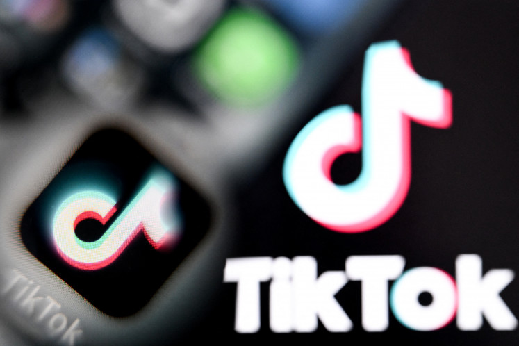 A photo taken on April 10, 2025 shows the Chinese social networking service TikTok's logos on a smartphone screen and laptop screen in Frankfurt am Main, western Germany. US President Donald Trump on September 16, 2025, extended a delay on enforcing a potential ban against TikTok until December 16, marking the fourth postponement of a law designed to force the app's sale from its Chinese owner. The announcement, made through an executive order, came despite Trump telling reporters Tuesday that the United States and China had reached a deal over a new ownership structure for TikTok.