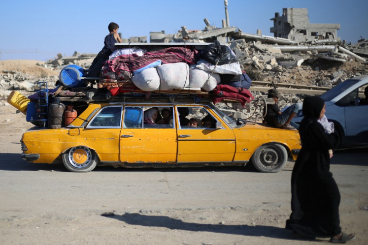 Displaced Palestinians move with their belongings southwards on a road in the Nuseirat refugee camp area in the central Gaza Strip following renewed Israeli evacuation orders for Gaza City on September 16, 2025. 