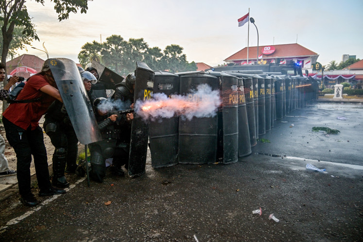 Police fire tear gas to disperse demonstrators during a protest on Aug. 29 against the Mobile Brigade Corps (Brimbob), after the death of a motorbike taxi driver the previous night, in front of the governor's residence in Surabaya.