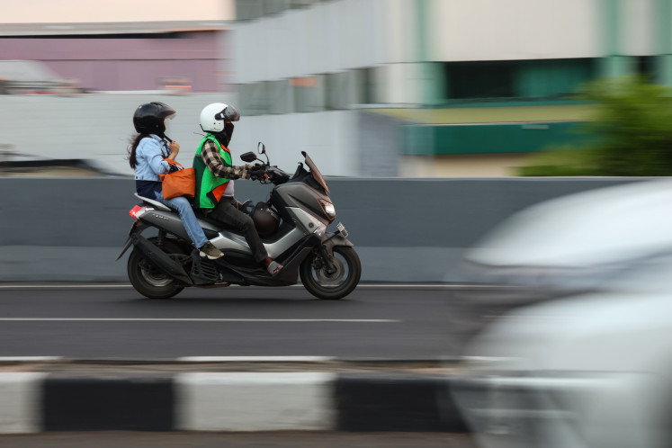 An online motorcycle taxi (ojol) driver picks up a passenger in Makassar, South Sulawesi, on Sept.16, 2025.