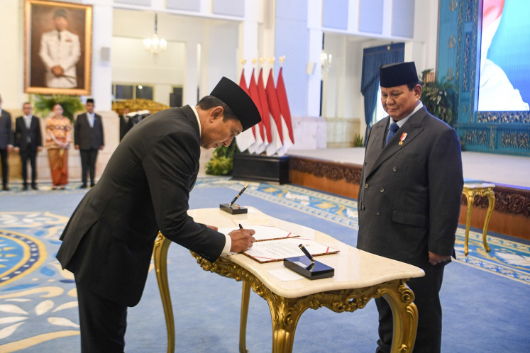 President Prabowo Subianto (right) witnesses as special presidential adviser on public order, safety and police reform Ahmad Dofiti (left) signs a document on Wednesday during the inauguration ceremony of new cabinet members at the State Palace in Jakarta. Prabowo inaugurates several new cabinet members, including Coordinating Politics and Security Minister Djamari Chaniago and Youth and Sports Minister Erick Thohir, in the second reshuffle of his administration.