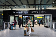 People walk at Terminal 2 of the Heathrow International Airport, a day after a fire at a nearby electrical substation wiped out the power at the airport, near London, Britain, on March 22, 2025.
