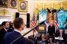 President Donald Trump, accompanied by US Commerce Secretary Howard Lutnick (second right), takes a question from a reporter after signing an executive order in the Oval Office at the White House on Sept. 19, 2025 in Washington, DC. Trump signed two executive orders, establishing the “Trump Gold Card“ and introducing a $100,000 fee for H-1B visas.