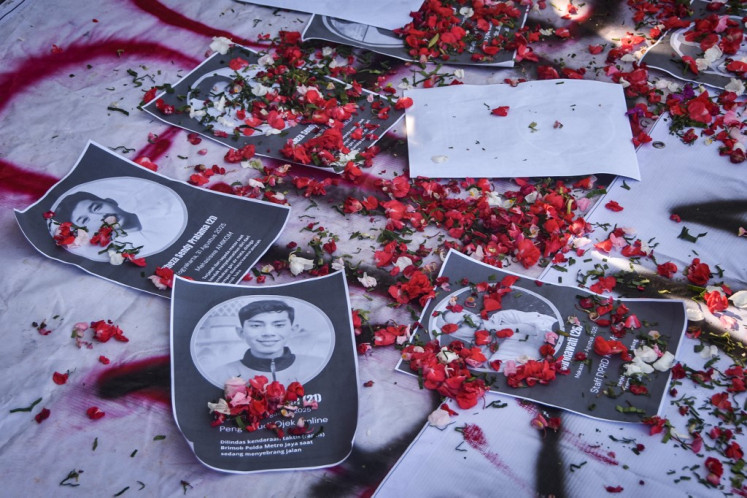 Flower petals are seen scattered on Sept. 4 on top of portraits of victims killed in recent clashes between demonstrators and police across the country during a memorial held by university students in Bekasi, West Java. At least 10 people were killed during recent violent protests in Indonesia.