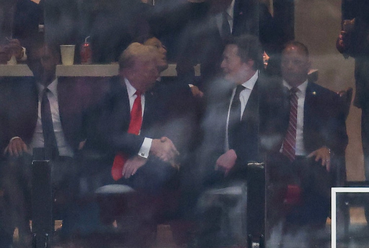US President Donald Trump and Tesla CEO Elon Musk shake hands during the public memorial service for right-wing activist Charlie Kirk at State Farm Stadium in Glendale, Arizona, on September 21, 2025. 