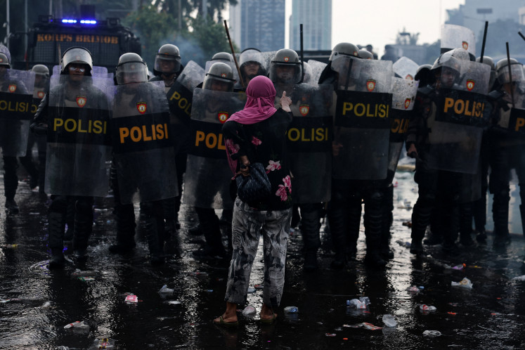 A woman confronts riot police during clash on Aug. 28, 2025, at a protest outside the House of Representative complex in Jakarta. 