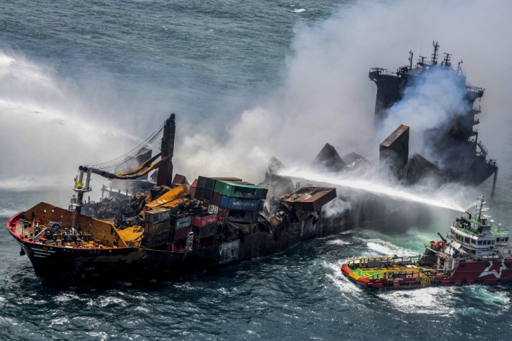 This handout photograph taken and released by the Sri Lanka Air Force on May 30, 2021 shows smoke billowing from the Singapore-registered container ship MV X-Press Pearl, which has been burning for the eleventh consecutive day as vessels try to douse off the fire, in the sea off Sri Lanka's Colombo Harbor, in Colombo.  
