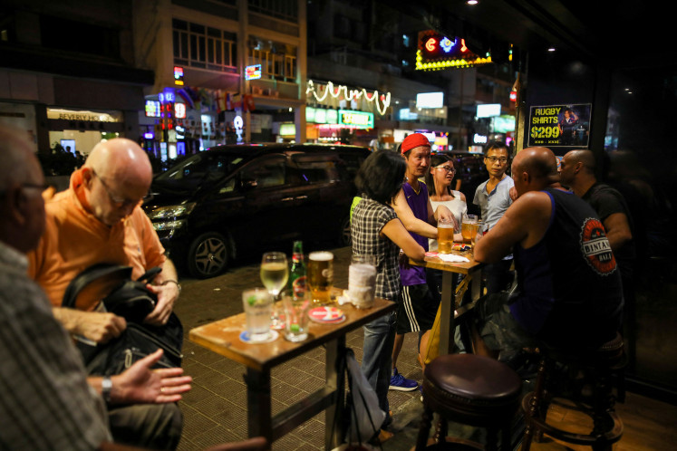 People have a drink inside a bar in Hong Kong, China October 25, 2019.