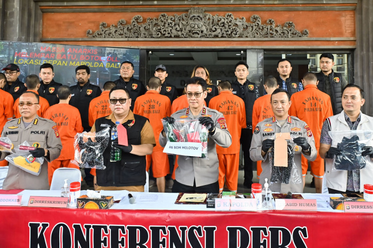 Bali Police chief Insp. Gen. Daniel Adityajaya (center), general crimes director Comr. I Gede Adhi Mulyawarman (second left), spokesperson Comr. Ariasandy, cybercrimes director Comr. Ranefli Dian Candra (right) and medical division head Comr. dr. Komang Nurada Mahardana (left) display evidence and suspects arrested for allegedly inciting riots during a press briefing at the Bali Police headquarters in Denpasar, Bali on Sept. 16, 2025. The Bali Police arrested 14 people for alleged incitement and involvement in violent riots during anti-government protests in the region in late August.