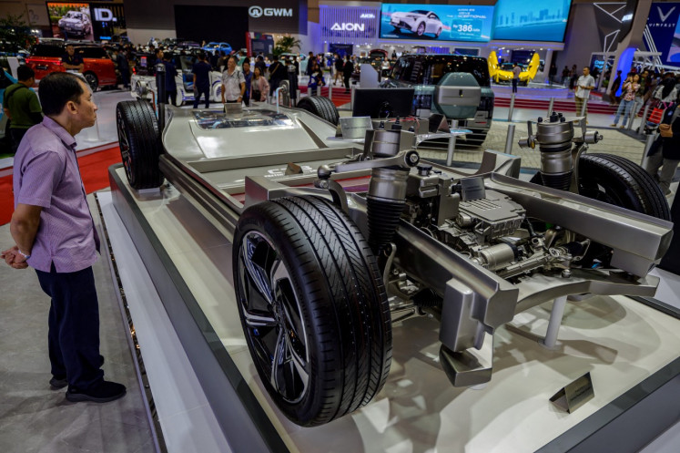 A visitor stands next to a module of an electric vehicle (EV) on July 18, 2024 during the Gaikindo Indonesia International Auto Show 2024 in Tangerang, Banten. 