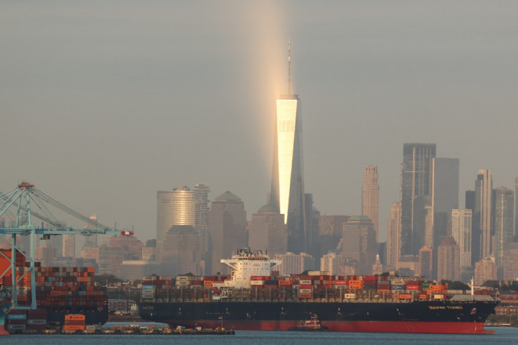 Cargo ships and shipping containers are seen at the Port Jersey Container Terminal, with the Manhattan skyline and the One World Trade Center (also known as the Freedom Tower) in the distance, in New Jersey, United States, on Sept. 22, 2025.