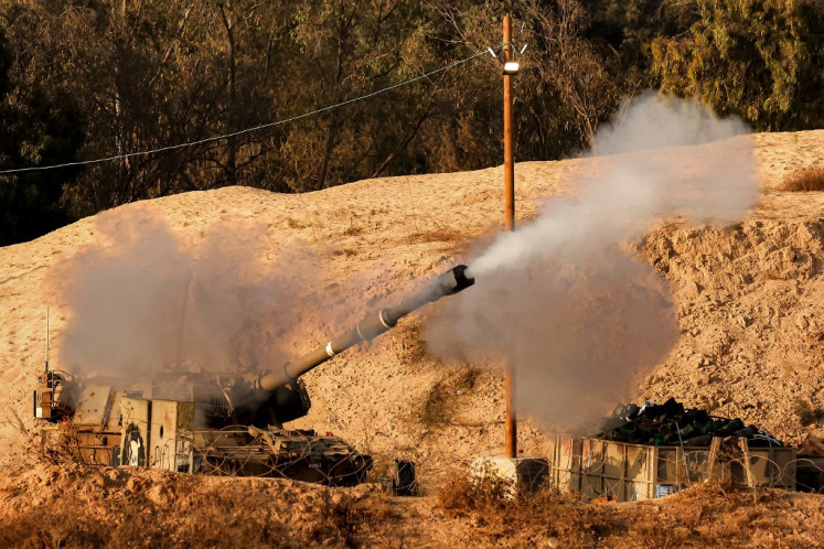 An Israeli army self-propelled artillery Howitzer fires rounds from a position along the border with the Gaza Strip in southern Israel on September 30, 2025.