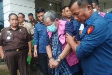 A suspect, identified only as BS, state-owned shipyard PT Dok dan Perkapalan Surabaya president director from 2017 to 2021, is assisted to a detention vehicle of the North Sumatra Prosecutor’s Office on Sept. 25, 2025 after being named a suspect in a corruption case relating to the procurement of two tugboats. Also named a suspect was HAP, the engineering director at state-owned port operator PT Pelabuhan Indonesia (Pelindo) I from 2018 to 2021. 