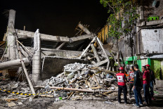 Desperate struggle: Rescue personnel inspect the site on Monday after a building collapsed at a pesantren (Islamic boarding school) in Sidoarjo, East Java.