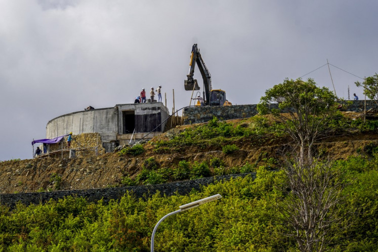 This picture taken on September 24, 2025 shows construction crew working on a hilltop, land which once belonged to villagers before it was taken over by the government to build the country's MotoGP racing circuit, in Lombok island, West Nusa Tenggara.