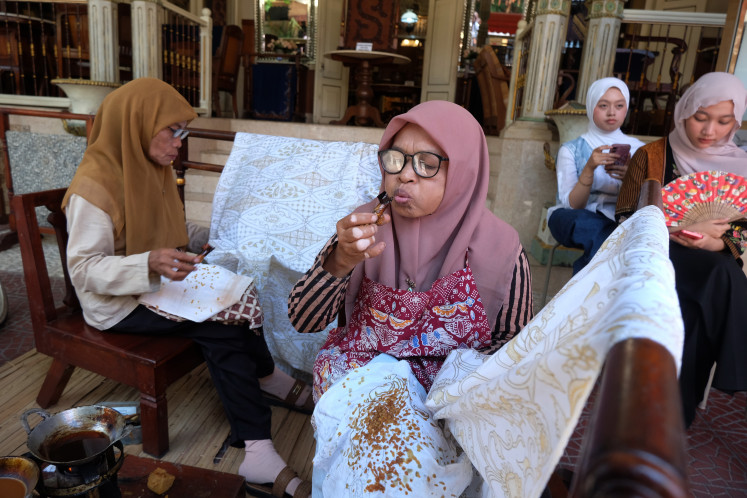 Threads of inspiration: Craftswomen demonstrate the batik painting process to visitors at Kampung Wisata Batik Kauman on Oct. 1 in Surakarta, Central Java. 