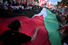 Pro-Palestinian demonstrators wave Palestinian flags and hold banners during a protest against the Israeli army's interception of the Global Sumud Flotilla at Plaza de Mayo square in Buenos Aires, on October 1, 2025. 