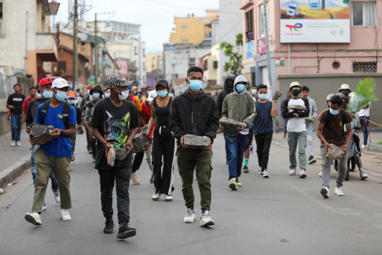 Protesters carry stones to erect a barricade during an anti-government protest in Ankadifotsy, Antananarivo, on October 1, 2025.