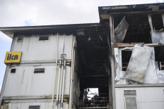 Police officers stand near Tower 14 after a fire at Construction Workers’ Housing (HPK) 1 in Nusantara, North Penajam Paser, East Kalimantan on Oct. 2, 2025. North Penajam Paser Police Chief Adj. Sr. Comr. Andreas Alex Danantara said the blaze, which broke out at around 5:30 p.m. local time on Oct. 1, gutted some 56 rooms on the second to fourth floors of the housing complex, which accommodates around 700 workers. 