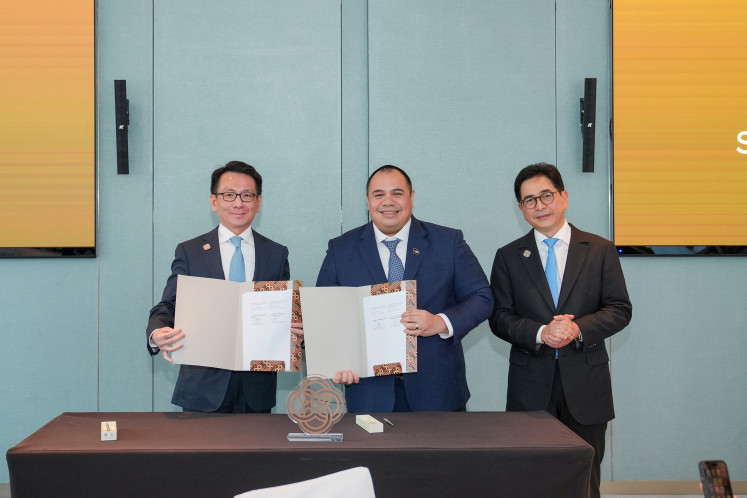 Sriwijaya Capital CEO Hartanto Tjitra (left) and Danantara chief investment officer Pandu Sjahrir (center) hold up memorandums of understanding during a signing ceremony and launch event for the private equity firm on Oct. 2, 2025, alongside Sriwijaya Capital founder chairman Arsjad Rasyid. (Courtesy of Sriwijaya Capital)