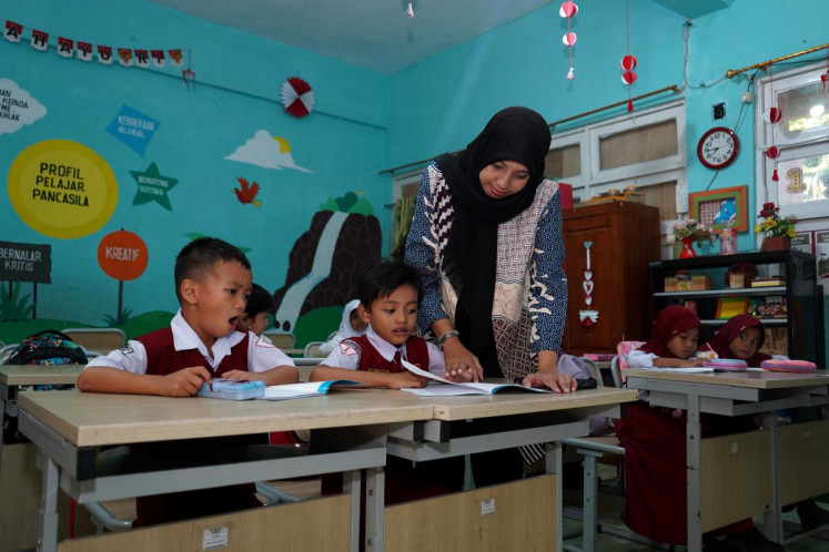 Primary guidance: A teacher checks a student’s work on Oct. 2, 2025 at SDN Sudirman II elementary school in Makassar, South Sulawesi.