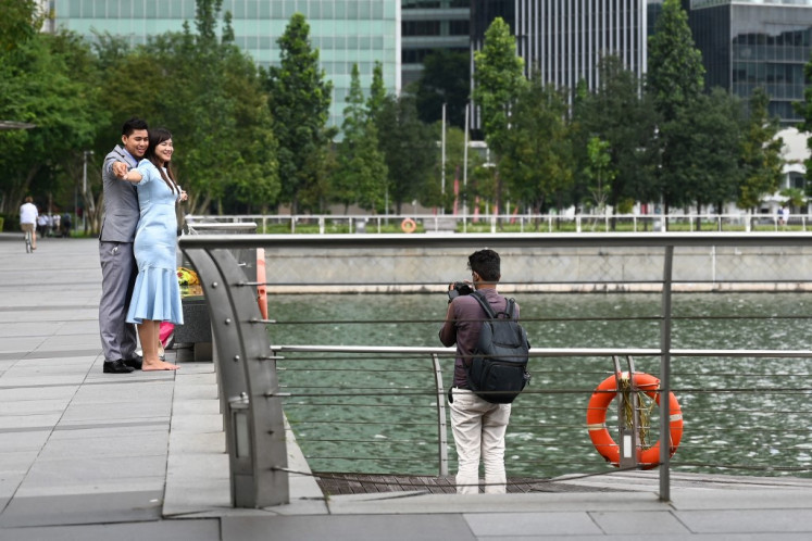 A couple poses on Feb. 28, 2022, during a pre-wedding photo shoot at the Marina Bay Waterfront Promenade in Singapore.