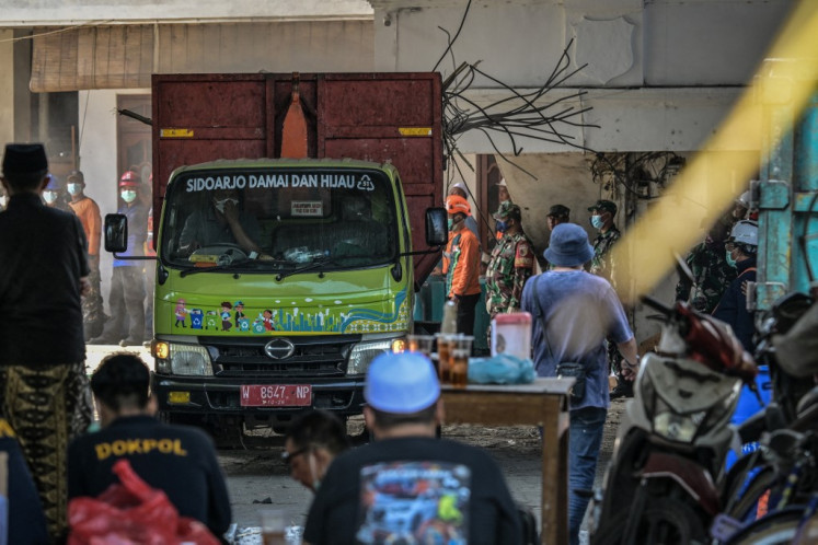 A truck carries debris from the collapsed Al Khoziny Islamic boarding school in Sidoarjo, East Java, on October 5, 2025, as rescuers continue searching for victims after a multi-storey building at the school collapsed. 
