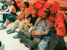 This handout picture released by the Israeli Foreign Ministry shows Swedish climate activist Greta Thunberg (center) and Brazilian activist Thiago Avila (right), along with other activists, after the Israeli navy intercepted the Global Sumud Flotilla carrying humanitarian aid to Gaza on October 1, 2025, as stated by the ministry. 