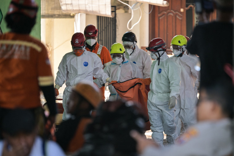 First responders carry a body bag on Oct. 6, 2025, amid ongoing search and rescue efforts at Pondok Pesantren Al Khoziny, an Islamic boarding school in Sidoarjo, East Java, where a three-story prayer hall collapsed on top of dozens of students on Sept. 29.