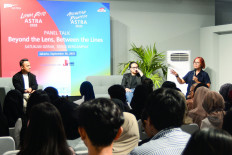 The Jakarta Post's archive editor and specialist Okky Ardya (right) speaks on Tuesday, as the Post's journalist Dio Suhenda (center) and master of ceremony Ari Sanjaya (left) look on, during the “Beyond the Lens, Between the Lines“ public discussion, supported by ASTRA Awarding Journalist, at JPLive! Space in The Jakarta Post Building in Jakarta.