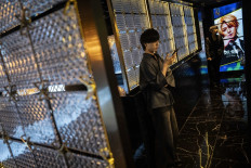 A man checks his phone at a club in the Kabukicho area of Tokyo on July 12, 2025.