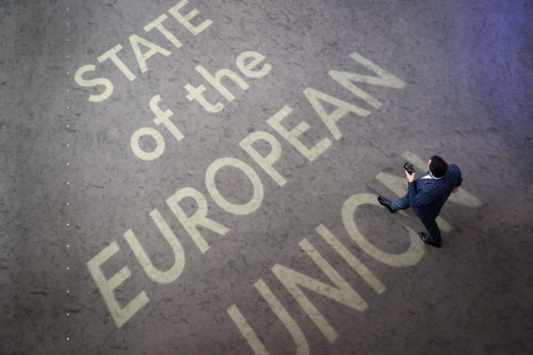 A man passes on a light sign reading “State of the European union“ on Sept. 10, the day of the European Union Commission President 's annual State of the Union address during a plenary session at the European Parliament in Strasbourg, eastern France. 