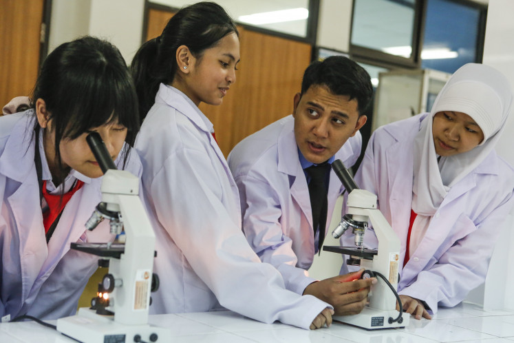 A teacher demonstrates the use of a microscope to students at SMAN Unggulan MH Thamrin in Cipayung, East Jakarta, on Oct. 8, 2025. The school is one of 12 schools selected for transformation under the Garuda School program, one of President Prabowo Subianto's education initiatives.