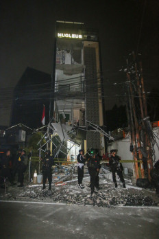 Several Gegana bomb squad personnel from the Jakarta Police stand guard on Thursday in front of the destroyed building of pharmaceutical company PT Nucleus Farma in South Tangerang, Banten. An explosion occurred at the site at around 8:30 p.m. 