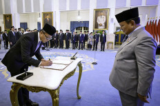 Dony Oskaria (left) signs an official decree as President Prabowo Subianto inaugurates the head and deputy heads of the State-Owned Enterprises (SOEs) Regulatory Agency (BP BUMN) at the State Palace in Jakarta on Oct. 8, 2025.